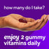 Two dark red VF Iron Gummy vitamins in a hand, asking 'how many do I take?' Consume 2 gummy vitamins daily for best results.