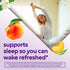 Young woman stretching in bed with jasmine and peaches, for Melatonin Gummies. Text: 'supports sleep so you can wake refreshed'.